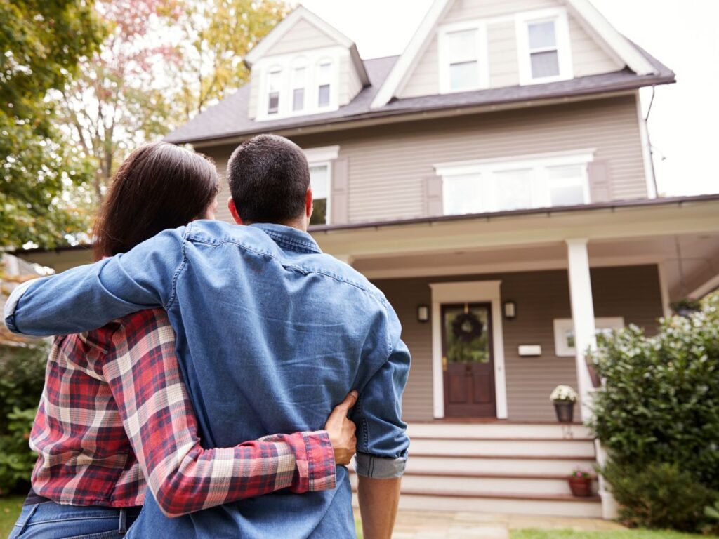 couple hugging and looking at their new house